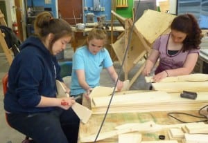 From left, Jasmine Long, Sarah Newlun and Kayla Drumm sand down ceremonial dance paddles during an arts workshp during the Yakutat Tern Festival. Photo by Ed Schoenfeld, CoastAlaska News.