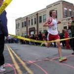 Sitka High freshman David Wilcox blazes across the finish line Saturday morning (9-28-13). Faced with its largest projected budget deficit in recent memory, the Sitka School Board may consider dramatic cuts to sports and activities programs in 2016. (KCAW photo/Robert Woolsey)