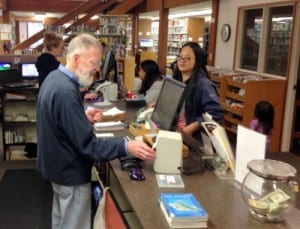 Librarian Brooke Schafer (rear) and volunteer Don Muller will now be handling library materials from across the state. (KCAW photo/Robert Woolsey)