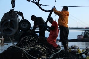 Crew members on the Star Shadow make repairs after the second day of herring fishing in 2015. From left: Brandon Ihde, Billy Nestle, and Devin Jones. (Rachel Waldholz/KCAW)