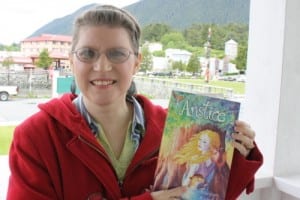 Sitka resident Marjean Ragsdale poses with her book, "Anstice." The cover was designed by Sitka artist Jessica Lynn Clark. (KCAW photo by Ed Ronco)