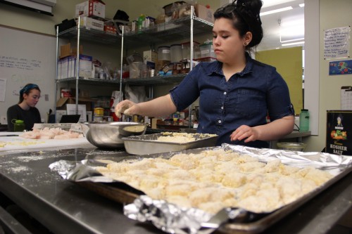 Pacific High Freshman, Oleana Valley makes lunch for her classmates as AmeriCorp volunteer Abby Long plans future recipes.