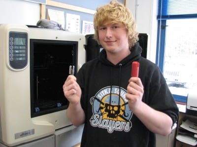 Sitka High senior Thor Becker with the product (l.) and the prototype bit made in this 3D printer. (KCAW photo/Robert Woolsey)
