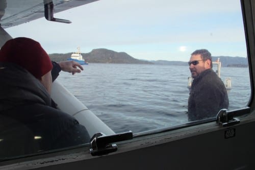 ADF&G biologist Dave Gordon disembarks from a float plane after an aerial survey of Sitka Sound, headed for the state research vessel, the Kestrel. (KCAW photo/Rachel Waldholz)