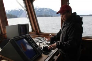 Captain Lito Skeek, of Petersburg, keeps an eye on the Kestrel's sonar during a survey of Sitka Sound. (KCAW photo/Rachel Waldholz)