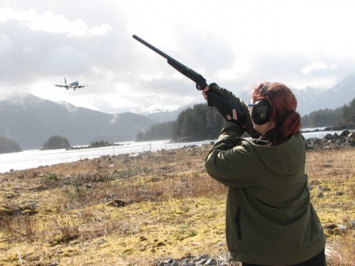 Wildlife specialist Heather Bauscher, uses a shotgun loaded with pyrotechnic shells to chase eagles off of Sitka's runway.(KCAW photo/by Emily Forman)