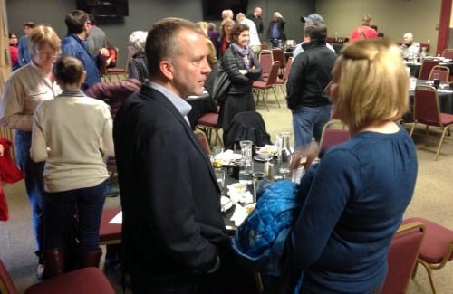 Sen. Dan Sullivan chats with Chamber board member and Baranof Island Brewery Co. owner Suzan Hess. Sullivan told Sitka's business community that the key to paying down the national debt was "growing the economy." (KCAW photo/Robert Woolsey)