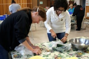 Sitka residents learn how to pickle and ferment fruits and vegetables at Sitka Kitch in mid-July. Pictured above, class participants Charlotte Candelaria (left) and Angelina Rubio (right) prepare to make pickled squash. KCAW photo/Vanessa Walker.